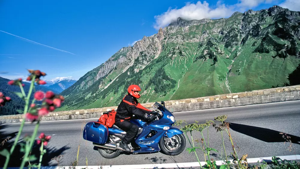 Motorrad auf der Arlbergpassstraße vor grüner Bergflanke Motorrad auf der Arlbergpassstraße vor grüner Bergflanke